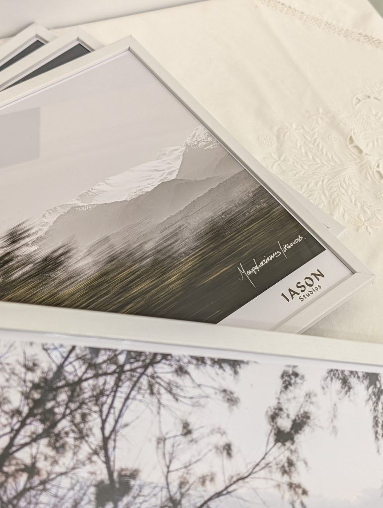 four white frames with photographs of Chania laid on the table of the gallery